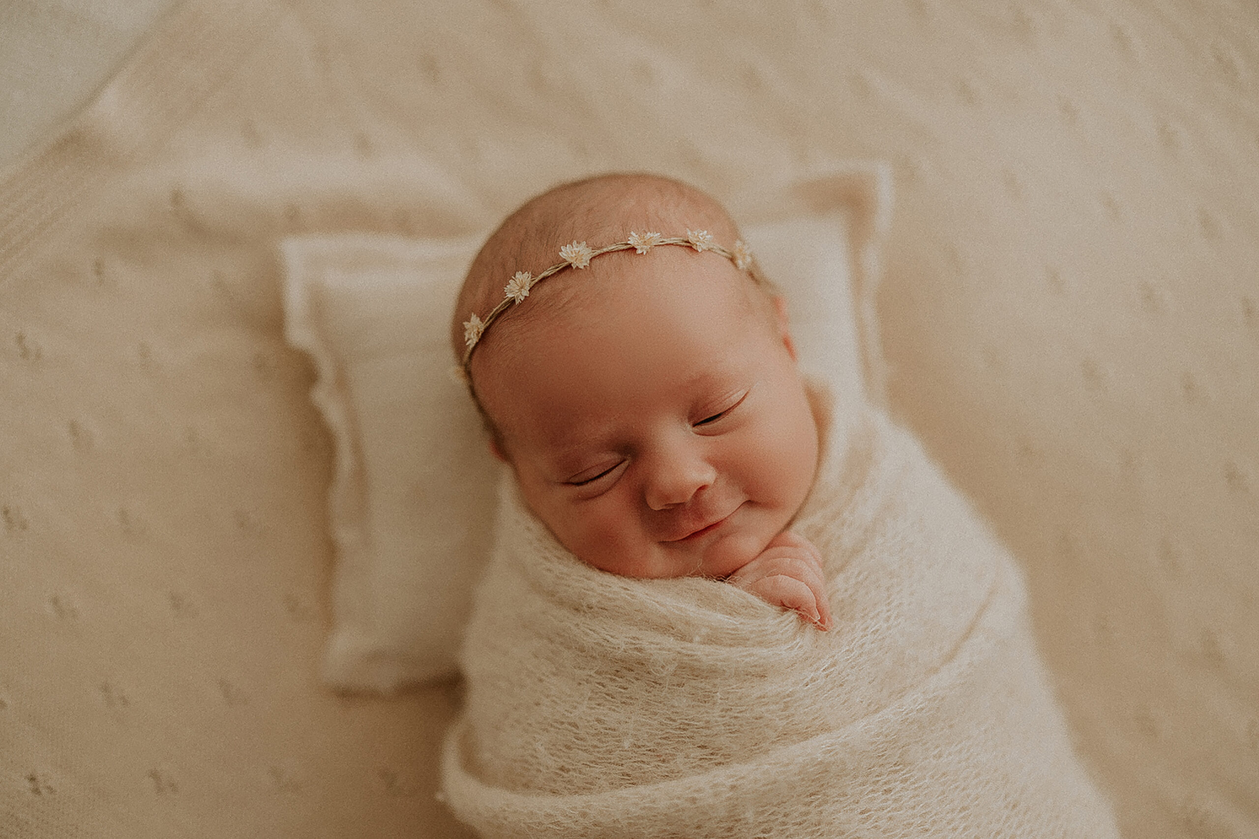 smiling swaddled newborn
