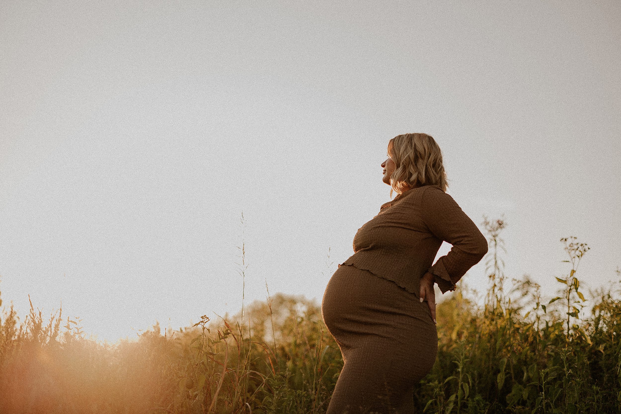 expecting mom in field at sunset