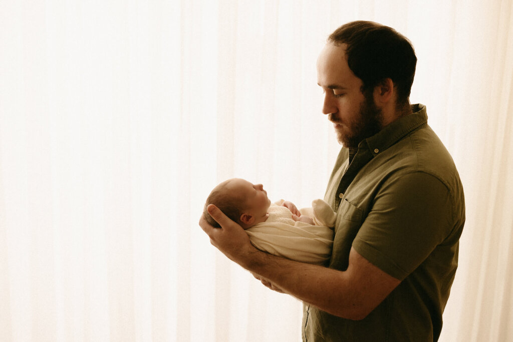 photographing a dad and newborn snuggling in the nashville studio