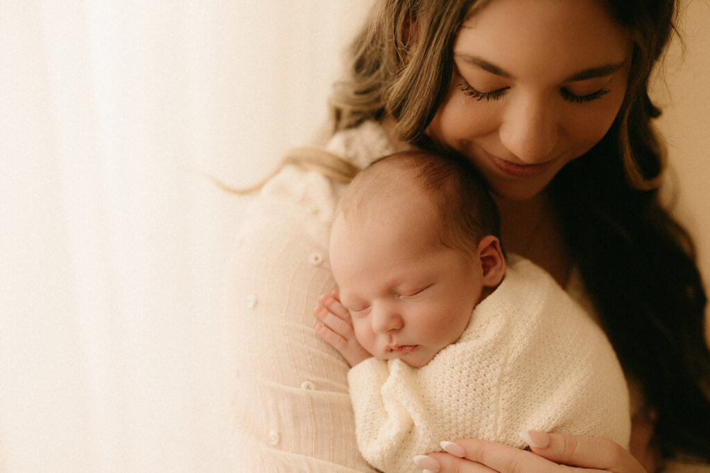 Rylan's Riches photography a Nashville Newborn Photographer photographing a mom and newborn snuggling in the studio